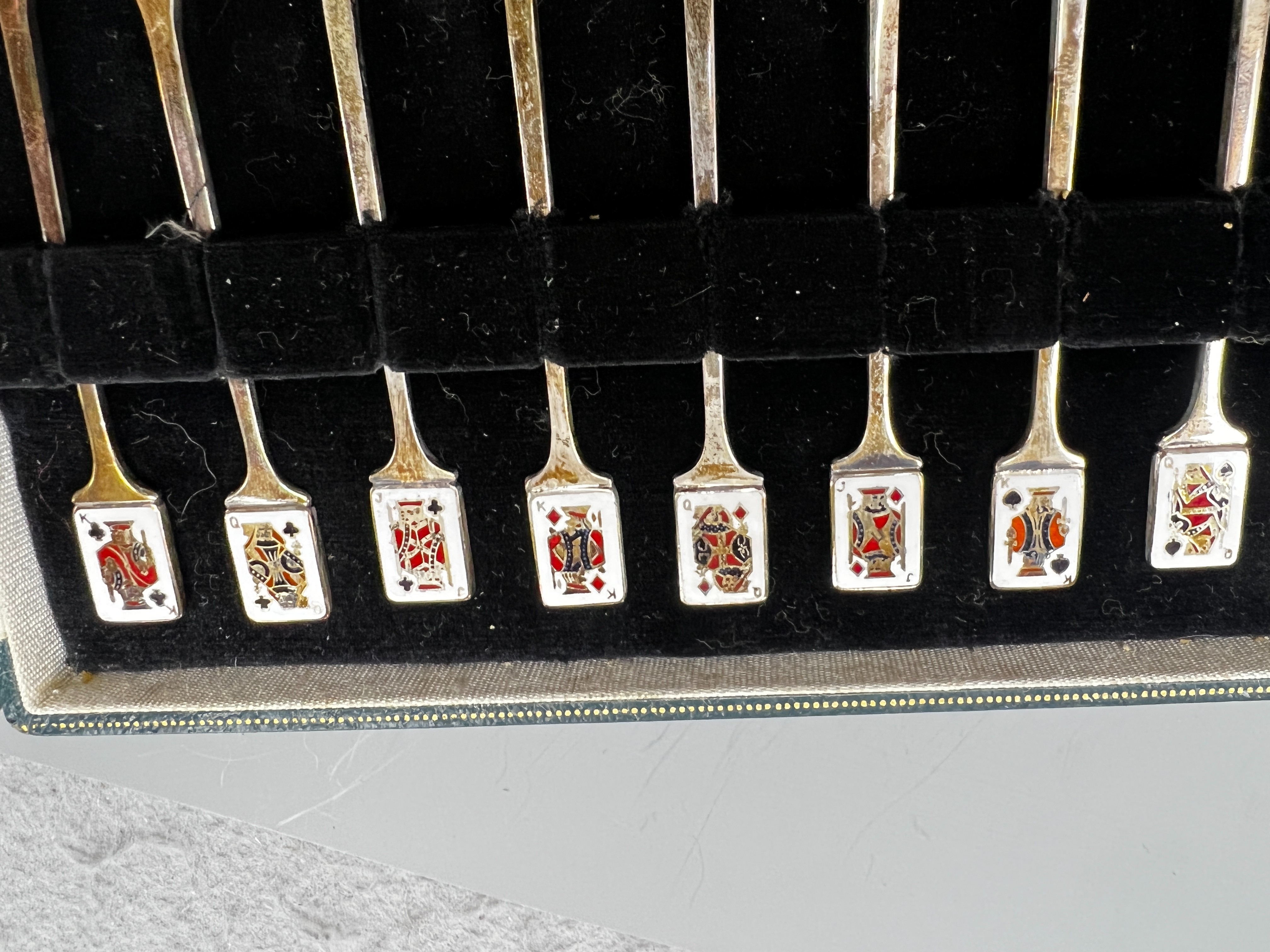 A cased set of twelve early 1960's silver and enamel cocktail sticks, by Garrard & Co, with playing card terminals, Birmingham, 1961.